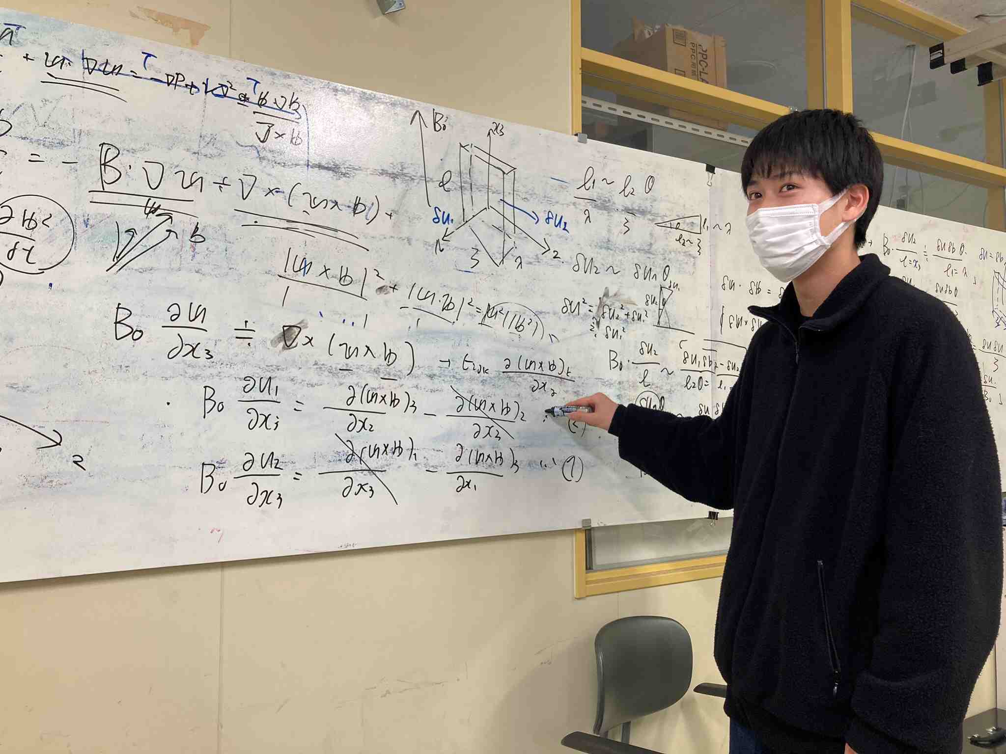 ホワイトボードを使って流体力学を検討する学生